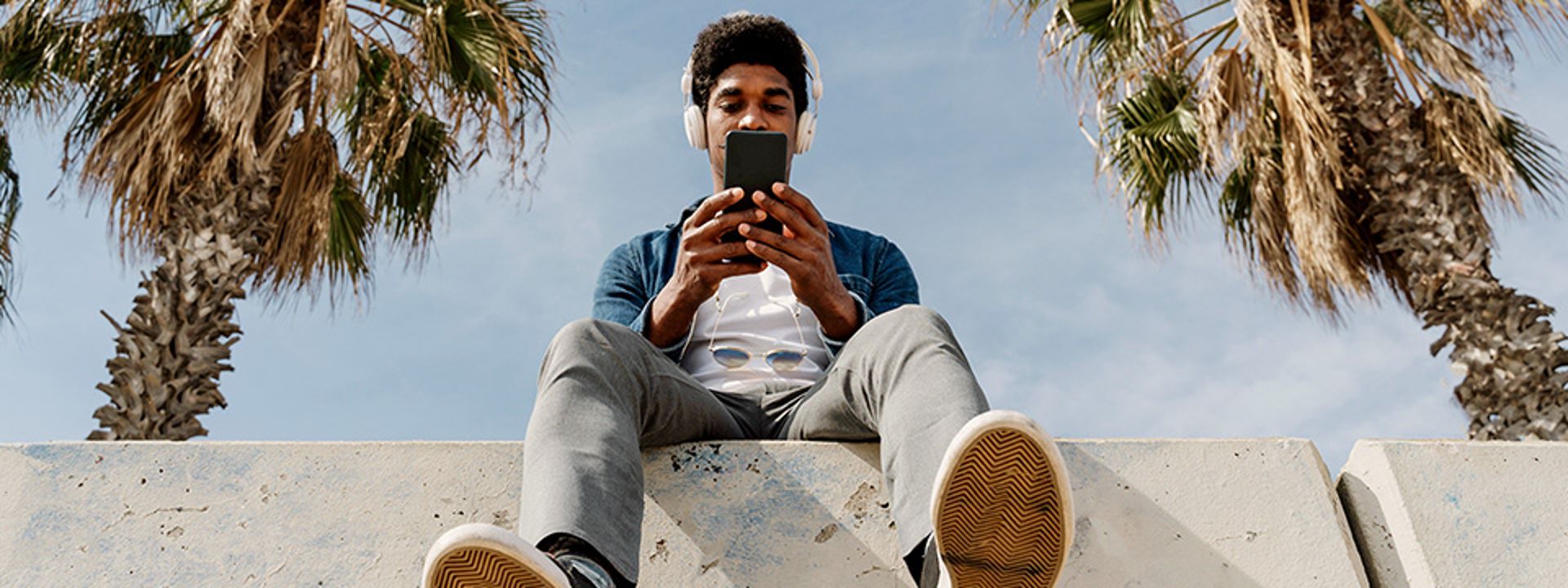 man sat on wall using mobile