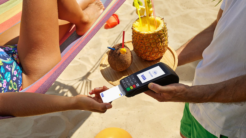 person on a hammock paying with their Visa card